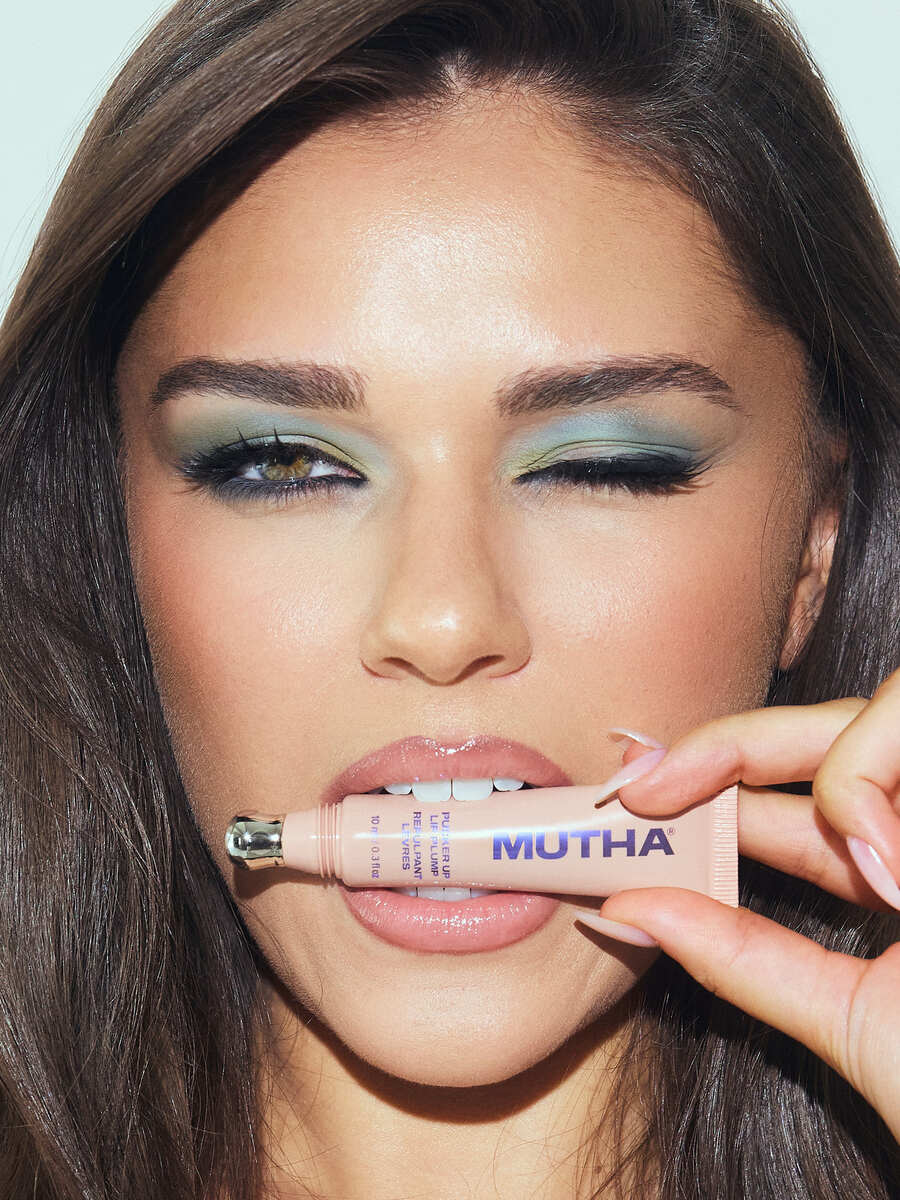 Brook Walmart of CGM Models holding MUTHA Pucker Up Plumping Lip Treatment across her glossy lips, photographed by Josh Eskridge at Know Good Studio in Miami with makeup by Shani Gottlieb.